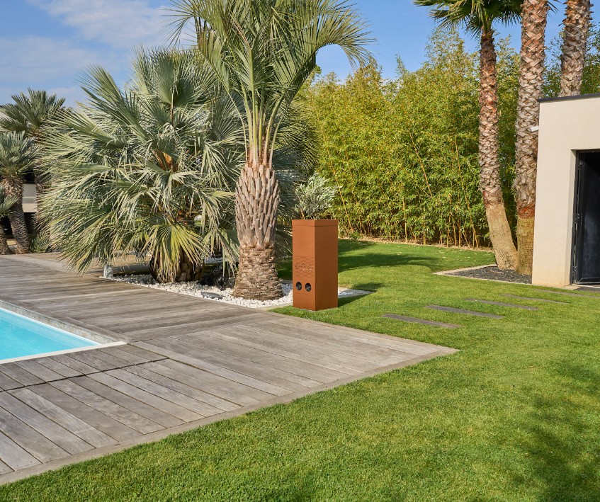 Jardin paysager : palmiers, pelouse et plage en bois