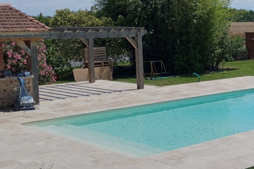 Piscine avec plage en travertin et pergola